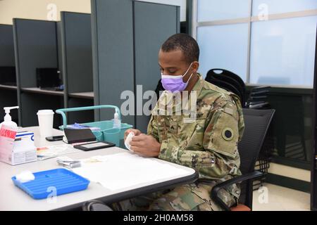 I soldati con la Task Force della Guardia Nazionale del Michigan (MING) Spartan, somministrano vaccini COVID-19 per la popolazione anziana, Grand Valley Frederik Meijer Campus, Holland, Michigan, 12 gennaio 2021. Lo stato del Michigan Department of Health and Human Services (MDHHS) ha richiesto supporto per le vaccinazioni COVID-19 a livello statale. La MDHHS e MING hanno lavorato insieme per tutta la pandemia e sono aumentati con i dipartimenti sanitari locali come richiesto nella consegna della vaccinazione a Michiganders. A partire da gennaio 10, IL MING ha somministrato più di 12,000 vaccinazioni. Foto Stock