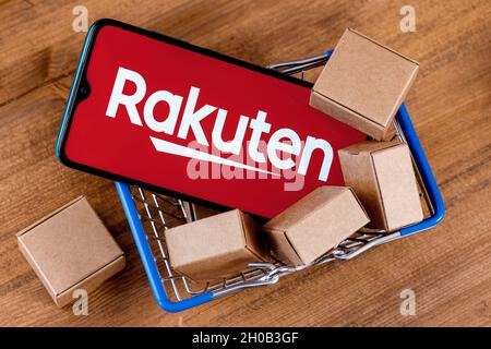 Rakuten Group è un'azienda giapponese di commercio elettronico e di vendita al dettaglio online. Smartphone con logo Rakuten sullo schermo e pacchi nel carrello. Foto Stock