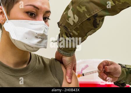 Senior Airman Bianca Robichaud, 436th Health Care Operations Squadron agente non commissionato di salute della famiglia, è somministrato il vaccino COVID-19 da staff Sgt. Kelsey Loeser, 436th Medical Group Unit Training Manager, 15 gennaio 2021, presso la base militare dover Air Force base, Delaware. Robichaud è stata la prima persona in trattamento con dover AFB a ricevere il vaccino COVID-19. Il vaccino è stato autorizzato per uso di emergenza dalla Food and Drug Administration statunitense per uso nella prevenzione di COVID-19. Foto Stock