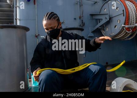 OKINAWA, Giappone (Gen. 15, 2021) il Boatswain's Mate Seaman Tyler Newkirk, di Raleigh, N.C., stabilisce linee di navigazione per le stazioni di ormeggio a bordo della USS America (LHA 6). L'America, parte dell'America Amphibious Ready Group, insieme alla 31 Marine Expeditionary Unit, opera nell'area di responsabilità della settima flotta statunitense per migliorare l'interoperabilità con alleati e partner, fungendo da forza di reazione pronta a difendere la pace e la stabilità nella regione del Pacifico. Foto Stock