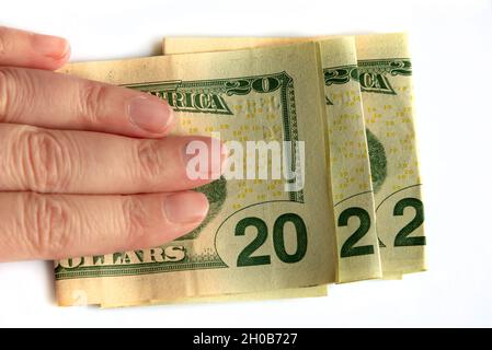 2022 scritto con banconote in dollari in una mano isolato su sfondo bianco, nuovo anno saluti concetto di denaro Foto Stock