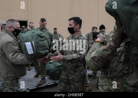 I membri della B Troop, 1° Squadron, 94° Reggimento Cavalry, Guardia Nazionale dell'Esercito del Minnesota, caricano l'ingranaggio in un camion in preparazione al movimento della truppa dalla base congiunta Andrews, Maryland, alla loro prossima destinazione, mentre prendono parte alla guida fino alla 59a Inaugurazione Presidenziale, 16 gennaio 2021. I soldati della Guardia Nazionale e gli Airmen di diversi stati si sono recati a Washington per fornire supporto alle autorità federali e distrettuali che hanno portato alla 59a Inaugurazione Presidenziale. Foto Stock