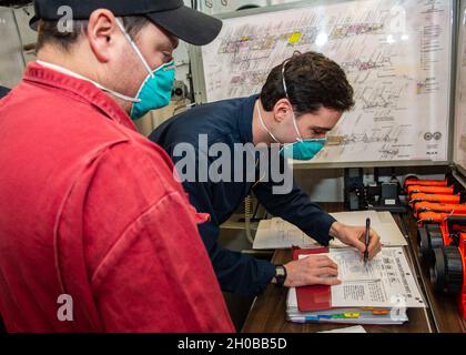 210116-N-RG587-1017 OCEANO ATLANTICO (GEN. 16, 2021) Damage Controlman Petty Officer 1st Class Michael Foster, left, osserva Ensign Julian Frink, scrivi un messaggio vuoto durante un'esercitazione in mare a bordo dell'incrociatore missilistico guidato classe Ticonderoga USS Vella Gulf (CG 72) 16 gennaio 2021. Il Golfo di Vella è in corso nell'Oceano Atlantico e svolge le sue attività nell'ambito del gruppo Dwight D. Eisenhower Carrier Strike Group. Foto Stock