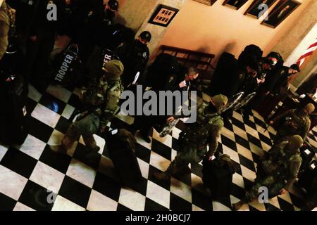 I soldati della polizia militare della Guardia Nazionale dell'Ohio camminano in archivio ad un posto fuori della Statehouse dell'Ohio il 17 gennaio 2021, a Columbus, Ohio. Diverse centinaia di membri della Guardia Nazionale dell'Ohio sono stati chiamati a dichiarare il dovere attivo di proteggere l'Ohio, i suoi cittadini, e gli edifici pubblici e la proprietà in previsione di potenziali dimostrazioni pubbliche relative all'inaugurazione presidenziale degli Stati Uniti il 20 gennaio. Foto Stock