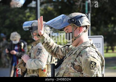 SPC dell'esercito degli Stati Uniti. Alexander Kerkeles della 270th Military Police Company, 185th Military Police Battaglione, 49th Military Police Brigade, California Army National Guard, risponde ad un motorista che ha inviato un'ondata amichevole 18 gennaio 2021, presso il Campidoglio dello stato di Sacramento, California. CAL Guardsmen continua a fornire ulteriore sicurezza presso le strutture federali e statali mentre la nazione si prepara per l’inaugurazione del neo-eletto presidente Biden il 20 gennaio. Foto Stock