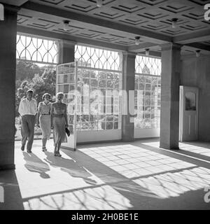 Ein Mann und zwei Frauen kommen in das Foyer des Kurhauses a Bad Cannstatt, Deutschland 1930er Jahre. Due donne e un uomo entra nella lobby del resort termale di Bad Cannstatt, Germania 1930s. Foto Stock