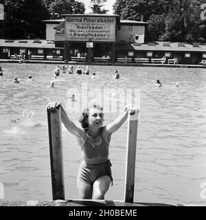 Eine Frau steigt aus dem Schwimmbecken eines Mineralbads, Deutschland 1930er Jahre. Una donna off arrampicata di una piscina termale, Germania 1930s. Foto Stock