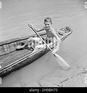 Ein kleiner Junge in seinem traditionellen Ruderboot auf der Donau bei Passau, Deutschland 1930er Jahre. Un ragazzino nel suo traditinal barca a remi sul fiume Danubio vicino a Passau, Germania 1930s. Foto Stock