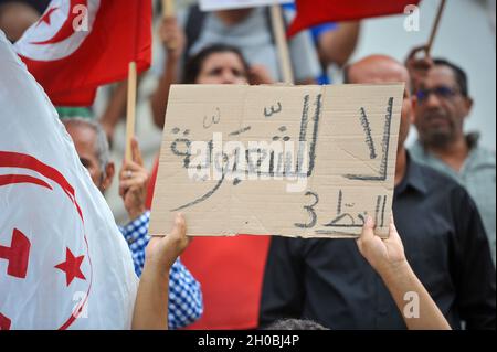 Non esclusiva: TUNISI, TUNISIA - 9 OTTOBRE 2021: I membri del partito laburista, tenere cartelli mentre prendono parte a una veglia gridando slogan 'No popul Foto Stock