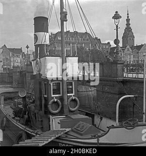 Boot im Hafen von Elbing mit der Liegebrücke und der Nikolaikirche im Hintergrund, Masurem, Ostpreußen, Deutschland 1930er Jahre. Barca al porto di Elbing Liegebruecke con il ponte e la chiesa di San Nicola in background, la Masuria - Prussia orientale, Germania 1930s. Foto Stock