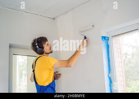 uomo che pulisce la parete bianca prima della verniciatura mentre rinnova l' interno Foto stock - Alamy