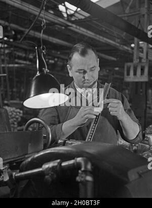 Arbeiter in einer Fabrikhalle bei Mercedes Benz a Stuttgart, Deutschland 1930er Jahre. Lavoratore in una fabbrica di Mercedes Benz a Stoccarda, Germania anni trenta. Foto Stock