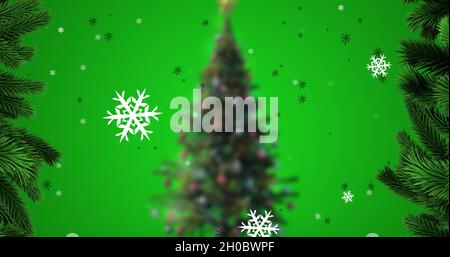 Immagine di fiocchi di neve cadenti sopra l'albero di natale Foto Stock