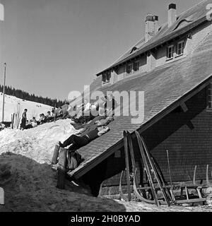 Winterurlauber beim Sonnenbad auf dem Dach einer Skihütte, Deutschland 1930er Jahre. I turisti dello sci a prendere il sole sul tetto di un rifugio sciistico, Germania 1930s. Foto Stock