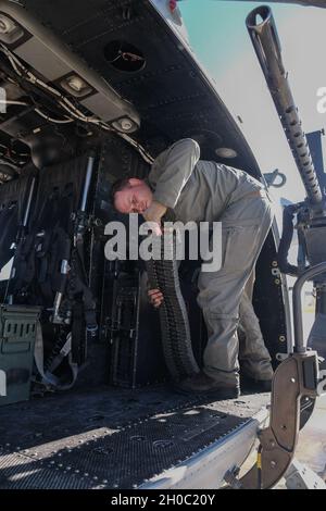 U.S. Marine Corps SSgt. Ryan Kidd, un capo dell'equipaggio di UH-1Y Venom con Marine Light Fighter Attack Helicopter Squadron (HMLA) 369, Marine Aircraft Group 39, 3rd Marine Aircraft Wing (MAW), carica le sue munizioni prima di un'esercitazione di supporto in aria durante l'esercizio Winter Fury sul Marine Corps Air Station Camp Pendleton, Calif., 21 gennaio 2021. Winter Fury mette in evidenza la capacità di 3rd MAW di combattere un avversario vicino-pari impiegando tutti gli aerei nel suo inventario, per includere F-35B Lightning II, AH-1Z Viper, UH-1Y Venom, F/A-18 Super Hornet, CH-53E Super Stallion, MV-22B Osprey e KC-130J Super Hercul Foto Stock