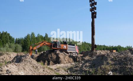 L'escavatore Orange scava la sabbia in un cantiere: Mosca, Russia - 30 agosto 2021 Foto Stock