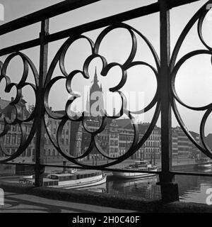 Der Kaiserdom San Bartolomeo und dem Mainufer a Francoforte durch eine Rosette Geländer im des Eisernen Stegs, Deutschland 1930er Jahre. Vista sulla città di Francoforte con la cattedrale e il fiume Main attraverso la ringhiera del ponte Eiserner Steg, Germania 1930s. Foto Stock