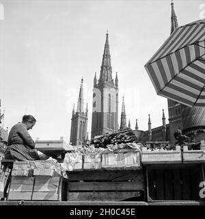 Frau mit ihrem Marktstand vor der Marktkirche in Wiesbaden, Deutschland 1930er Jahre. Donna con il suo stand del mercato di fronte alla chiesa Marktkirche a Wiesbaden, Germania 1930s. Foto Stock