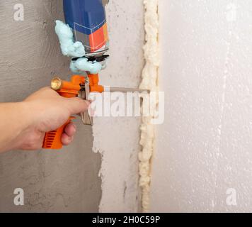 Pistola per schiuma da costruzione con cilindro difettoso. Difetto del flacone di schiuma Foto Stock