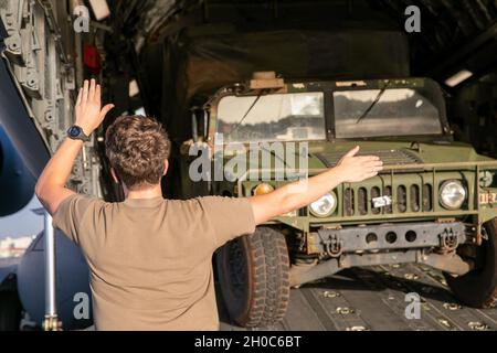 Artiglieri da B Battery, 3a Battaglione, 7a artiglieria da campo, 25° Artiglieria Divisione fanteria Inverti il loro Humvee in un Air Force C-17 Globemaster III in preparazione per l'operazione Bull Wings Emergency Deployment Readiness Exercise (EDRE) presso la base aerea di Hickam, Hawaii, 21 gennaio 2021. EDRE è un'esercitazione rapida e senza preavviso, progettata per testare la capacità di un'unità di avvisare, marshalling e implementare forze e apparecchiature in caso di emergenza o per operazioni di emergenza. Foto Stock