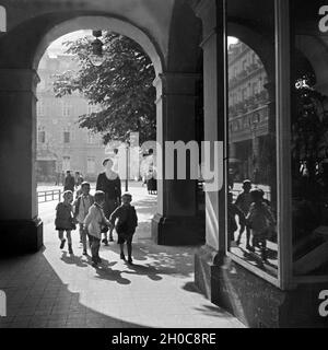 Eine Kindergärtnerin ist mit ihrer Kindergruppe unterwegs in der Innenstadt von Bad Ems, Deutschland 1930er Jahre. Un insegnante kinergarten passeggiando con il suo gruppo di bambini attraverso la parte interna della città di Bad Ems, Germania 1930s. Foto Stock