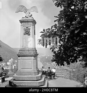 Menschen sitzen auf einer Anhöhe über der Lahn in Bad Ems un einem Ehrenmal, Deutschland 1930s. La gente seduta sopra la riva del fiume Lahn a Bad Ems a WWI memorial, Germania 1930s. Foto Stock