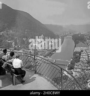 Menschen sitzen auf einer Anhöhe über der Lahn in Bad Ems genißen und die Aussicht, Deutschland 1930s. La gente seduta sopra la riva del fiume Lahn e godendo la vista a Bad Ems, Germania 1930s. Foto Stock