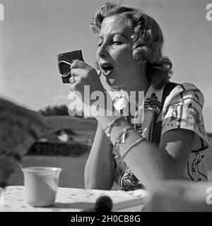 Eine junge Frau schminkt sich mit Hilfe eines kleinen Taschenspiegels, Österreich 1930er Jahre. Una giovane donna controllando il suo compongono con l aiuto di un piccolo specchio tascabile, Austria 1930s. Foto Stock