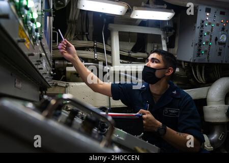 OCEANO PACIFICO (Gen. 21, 2021) Missile Technician 3rd Class Nicholas Soto, di Houston, Texas, assegnato all'equipaggio d'oro del sottomarino missilistico guidato di classe Ohio USS Ohio (SSGN 726), registra le temperature del tubo missilistico mentre si guarda al pannello di controllo e monitoraggio. L'Ohio sta conducendo la sorveglianza, la formazione ed altre missioni critiche nell'area di funzionamento della 7a flotta degli Stati Uniti. Foto Stock