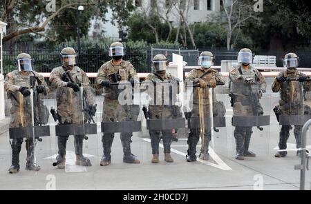 La polizia Nazionale dell'Esercito della California con la 270a compagnia di polizia militare, il 185o Battaglione di polizia militare, la 49a brigata di polizia militare, formano una linea difensiva per assistere con sicurezza al Campidoglio di Sacramento, California, 20 gennaio 2021 durante l'inaugurazione del Presidente Biden. Con la transizione delle potenze presidenziali, le forze della Guardia Cal furono attivate per proteggere e difendere vite, proprietà e diritti di tutti i californiani. Foto Stock