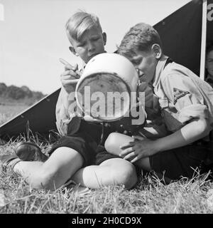 Zwei Hitlerjungen Zeltlager im beim Essen, Deutschland 1930er Jahre. Due giovani di Hitler a pranzo, Germania 1930s. Foto Stock