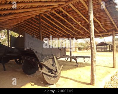 Carrozza in legno d'epoca parcheggiata sotto il tetto di paglia nella zona rurale Foto Stock