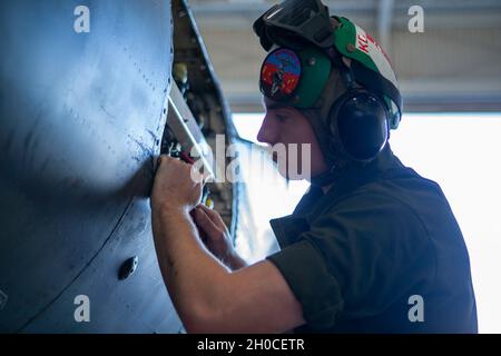 Lance Corporal Vincent farina, un meccanico di airframe, rimuove il vecchio sigillante da un pannello del AV-8B Harrier II alla stazione aerea del corpo marino Yuma, Arizona, gennaio 22, 2021.Marines con Marine Attack Training Squadron 203 (VMAT-203) addestrato con l'ordnance in un ambiente sconosciuto per aumentare la competenza in abilità mission critiche come tattiche a bassa altitudine, manovre complesse e supporto in aria stretta. VMAT-203 è un'unità subordinata della seconda Ala di aeromobili marini, l'elemento di combattimento aereo della II forza di spedizione marina. Foto Stock