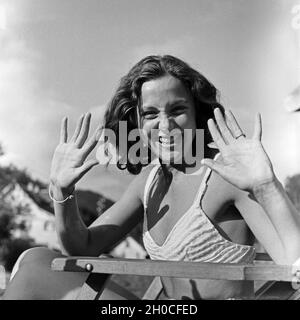 Eine junge Frau beim Sonnenbad am Schwimmbecken, Deutschland 1930 Jahre. Una giovane donna in posa mentre prendisole in piscina, Germania anni trenta. Foto Stock