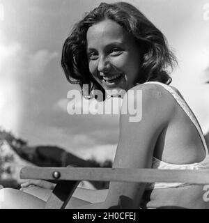 Eine junge Frau beim Sonnenbad am Schwimmbecken, Deutschland 1930 Jahre. Una giovane donna in posa mentre prendisole in piscina, Germania anni trenta. Foto Stock