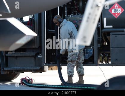 Un Airman assegnato al 48th Logistics Readiness Squadron arrotola il tubo del combustibile dopo il rifornimento caldo della fossa durante un'esercitazione integrata di giro di combattimento alla Royal Air Force Lakenheath, Inghilterra, 22 gennaio 2021. I pozzi caldi riducono i tempi di messa a terra tra un sorso e l'altro rifornendo gli aerei attivi, consentendo l'allenamento massimo in un arco di tempo più breve. Foto Stock