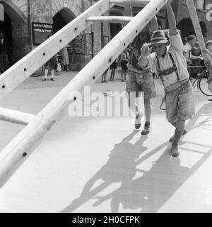 Handwerker beim Aufstellen einer Leiter in der Innenstadt von Innsbruck in Österreich, Deutschland 1930er Jahre. Gli artigiani mettendo su una scala al centro di Innsbruck in Austria e Germania 1930s. Foto Stock