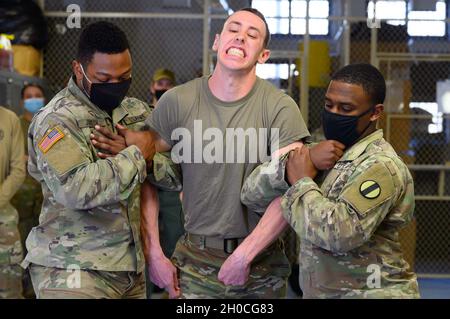 SPC dell'esercito degli Stati Uniti. Taylor Blanton, 3° operatore militare di Dog Detachment K-9, subisce l'esposizione a scosse elettriche da un Taser durante un evento di addestramento alla base comune di Langley-Eustis, Virginia, 22 gennaio 2021. I poliziotti militari sono tenuti a sottoporsi all'esposizione allo spray del capsicum di Taser e oleoresina come parte della loro qualifica per queste armi non letali. Foto Stock