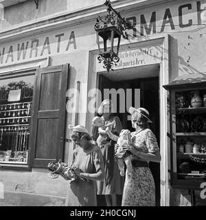 Drei junge Frauen haben in einem Uhrmachergeschäft Kunsthandwerksgegenstände eingekauft, Österreich 1930er Jahre. Tre giovani donne hanno comprato alcuni oggetti di artigianato in un orologio maker's shop, Austria 1930s. Foto Stock