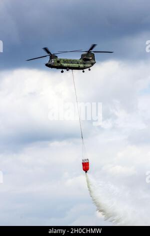 Boeing CH-47 Chinook elicottero goccia acqua da un secchio d'acqua. Gilze-Rijen, Paesi Bassi - 21 giugno 2014 Foto Stock