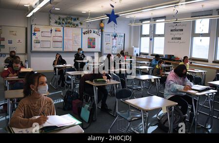 Gli studenti della scuola media prendono appunti in classe presso la scuola media Aviano sulla base aerea Aviano. Foto Stock