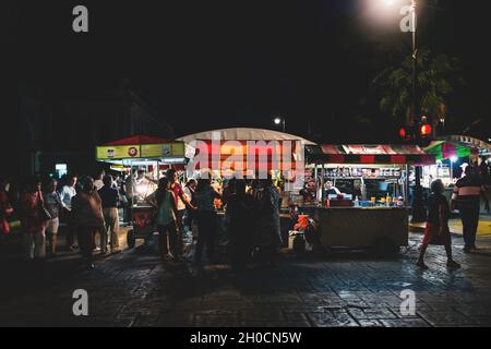 Merida, Messico: 28 ottobre 2018 - Vistori in attesa al mercato notturno con il cibo messicano stand presso la 'Plaza Grande' Foto Stock