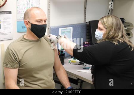 Alexander carter riceve una vaccinazione COVID-19 il 26 gennaio 2021, da Erica Miller, infermiera registrata presso la clinica sanitaria Fort McCoy, durante il primo turno di vaccinazioni COVID-19 a Fort McCoy, Wis. Carter è stato il terzo a ricevere il vaccino al posto. Lo sforzo è stato l'inizio di molti cicli di vaccinazioni all'installazione. Il vaccino COVID-19 è ora disponibile grazie in gran parte al Dipartimento della Difesa sforzo per l'operazione Warp Speed per ottenere vaccini per il popolo americano. Foto Stock