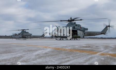 Un UH-1Y Huey e un AH-1Z Viper si preparano a decollo presso l'Alpena Combat Readiness Training Center, Michigan, 28 gennaio 2021. Marines con Marine Light Attack Squadron 167 (HMLA-167) addestrato con i soldati della Michigan Air National Guard per condurre operazioni di spedizione in un ambiente freddo. HMLA-167 è un'unità subordinata della seconda Ala di aeromobili marini, che è l'elemento di combattimento aereo della II forza di spedizione marina. Foto Stock