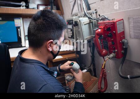 210128-N-WQ732-2005 OCEANO ATLANTICO (GEN. 28, 2021) – Interior Communications Electrician Petty Officer di terza classe Kevin Lorusso di Welch, Minnesota, effettua la manutenzione su un telefono con sistema di comunicazione vocale integrato (IVCS) a bordo dell'incrociatore missilistico guidato di classe Ticonderoga USS Monterey (CG 61), 28 gennaio 2021. Monterey è in corso nell'Oceano Atlantico come parte del Dwight D. Eisenhower Carrier Strike Group. Foto Stock