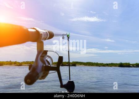 Pesca sul fiume in estate. Il concetto di hobby e tempo libero. Spazio di copia. Messa a fuoco selettiva Foto Stock