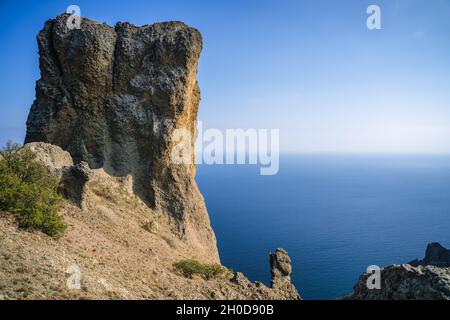 Rock chiamato Devil's Finger nella riserva naturale di Karadag contro il cielo blu. Mare nero. Crimea. Foto Stock