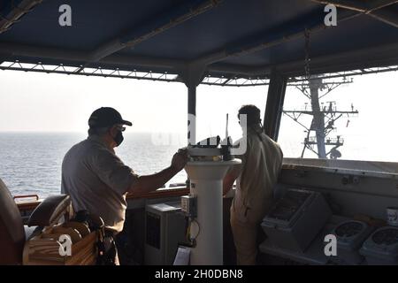 Da sinistra, dal ponte di USNS Yukon (T-AO 202) il capitano Daniel Glazier, maestro e capo Mate Michael Cook supervisiona un rifornimento in corso con USS Sterett (DDG 104). Yukon fa parte della forza logistica di combattimento della Marina degli Stati Uniti. L'oliatore di rifornimento della flotta fornisce carburante, carico e cibo alle navi della Marina degli Stati Uniti e dei partner internazionali che operano nella regione Indo-Pacific. Foto Stock