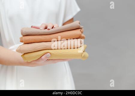 Immagine ritagliata di sorridere sarta azienda pila di tessuto colorato Foto Stock