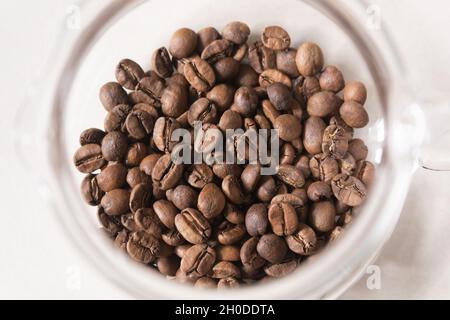 Chicchi di caffè arrosto in una caraffa di vetro Foto Stock